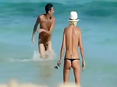 Skinny topless girl enters the water