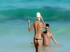 Skinny topless girl enters the water
