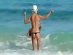 Skinny topless girl enters the water