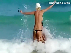 Skinny topless girl enters the water