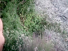 Naturist girl next to a small waterfall
