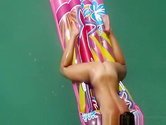 Hot nudist woman sunbathing in inflated air mattress