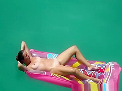 Hot nudist woman sunbathing in inflated air mattress