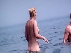 Tattooed nudist and other in beach