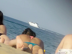 Asian teen girl bends over on beach