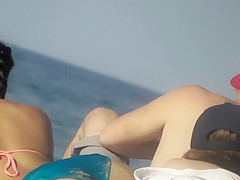 Asian teen girl bends over on beach