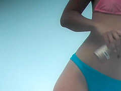 Asian teen girl bends over on beach