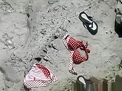 Nudist woman in her red towel sunbathing