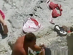 Nudist woman in her red towel sunbathing