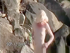 Small tits nudist at rocky beach