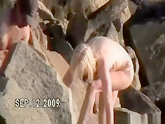 Small tits nudist at rocky beach