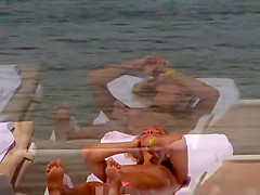 Topless girls relaxing by the beach