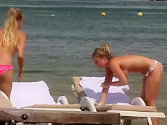 Topless girls relaxing by the beach