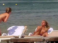 Topless girls relaxing by the beach