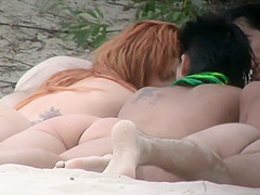 Nudists snuggling together on beach