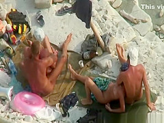Two nudist couples in beach