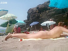 Nudist putting sun protection cream on friend