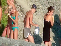 Nudists removing clothes on a beach