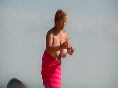 Gigantic mature tits on a beach