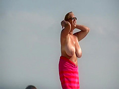 Gigantic mature tits on a beach