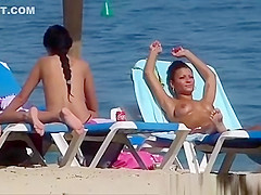 Pretty topless girls sunbathing on the beach