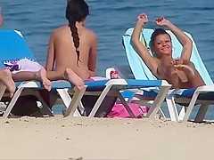 Pretty topless girls sunbathing on the beach