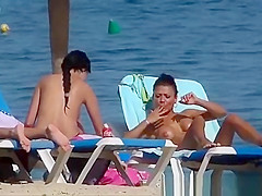 Pretty topless girls sunbathing on the beach