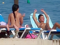 Pretty topless girls sunbathing on the beach