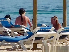 Pretty topless girls sunbathing on the beach