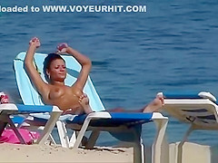 Pretty topless girls sunbathing on the beach