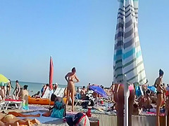 Curly hair topless chick at the beach