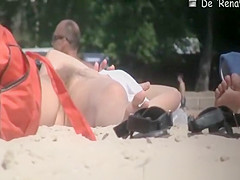 Nudist woman with small tits and shaved pussy sunbathing