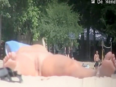 Nudist woman with small tits and shaved pussy sunbathing