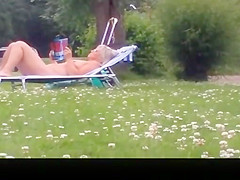 Nude mature woman reading a book