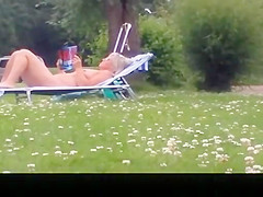 Nude mature woman reading a book