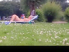 Nude mature woman reading a book