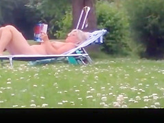 Nude mature woman reading a book