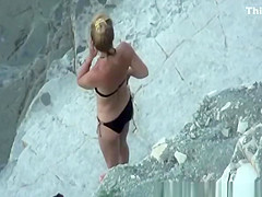 Nudist woman takes off her black bikini
