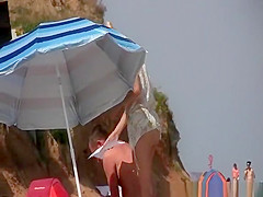 Nudist blonde with shaved pussy at beach