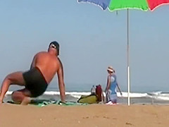 Hot lady gives a handjob at a beach