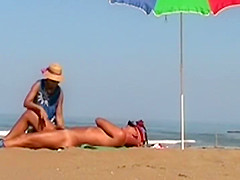 Hot lady gives a handjob at a beach