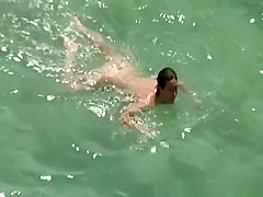 Nudist woman swimming in the fresh water
