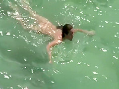 Nudist woman swimming in the fresh water