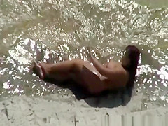 Chubby nudist woman sunbathing and swimming