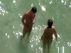 Chubby nudist woman sunbathing and swimming