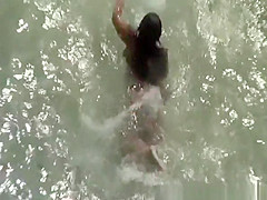 Chubby nudist woman sunbathing and swimming