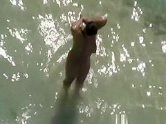 Chubby nudist woman sunbathing and swimming