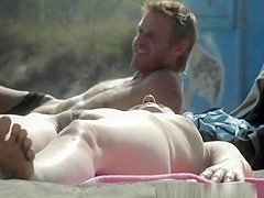 Nudist woman lying down in the sun sunbathing