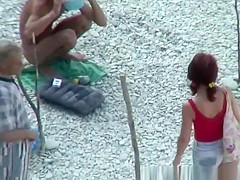 Nudists preparing their spot in the rocky beach