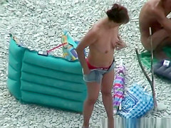 Nudists preparing their spot in the rocky beach